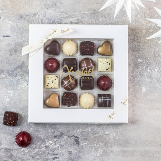 Elegant æske fra Christiansfelder Star-serien med 25 fyldte chokolader i forskellige smagsvarianter som marcipan, hasselnød, citron, lakrids, romkaramel, appelsin, kirsebærmarcipan, kahlua og saltkaramel – en luksuriøs gaveæske med håndlavet chokolade.