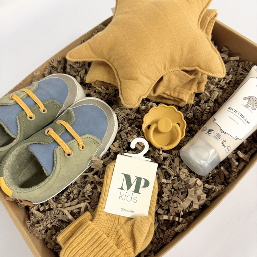 Barselsgave i varme farver med babysko, nusseklud, sut og babypleje