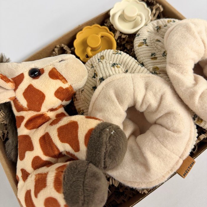 Barselsgave med blød girafbamse og blomstermønstrede futter – perfekt til nyfødte