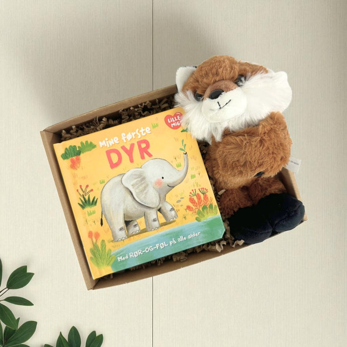 Sød gaveløsning med en ræv krammeven og en bog om babys første dyr