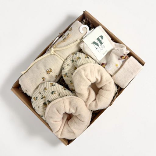 Barselsgave med beige babysokker, bløde futter og stofpose i neutrale farver.