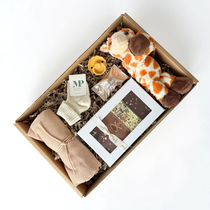 Barselsgave i brune nuancer med sød giraf krammebamse, stofble, sut, strømper og chokolade.