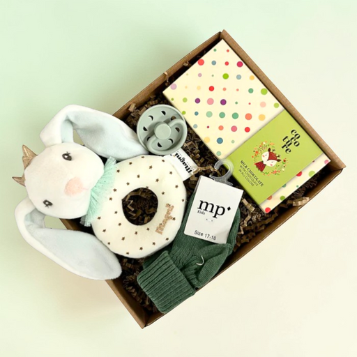 Barselsgave i grønne farver med strømper, sut, rangle og chokolade til søskende.