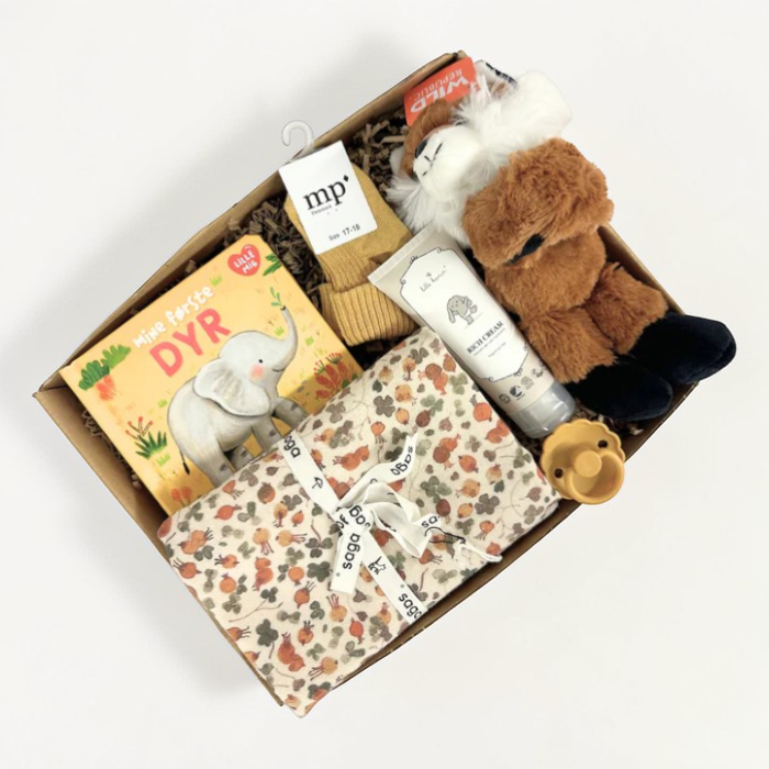 Sød gaveløsning med krammebamse, bog og andre sager til baby