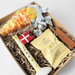 Gave til fars dag med dekorativt keramikflag, nøglering med teksten “Far” og søde sager pakket i gaveæske.