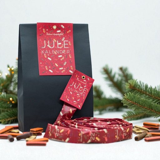 Dansk julekalender med håndlavet lakridskonfekt fra Hattesens Konfektfabrik – rød pose med 2,5 meter lang guirlande fyldt med konfekt i smagene jordbær, blodappelsin, ingefær, lakrids og chokolade. Nr: 2 Håndlavet lakridskonfekt fra Ærø i en julekalender – enkel rød pose med guirlande af farverigt konfekt i fem forskellige smagsvarianter.	