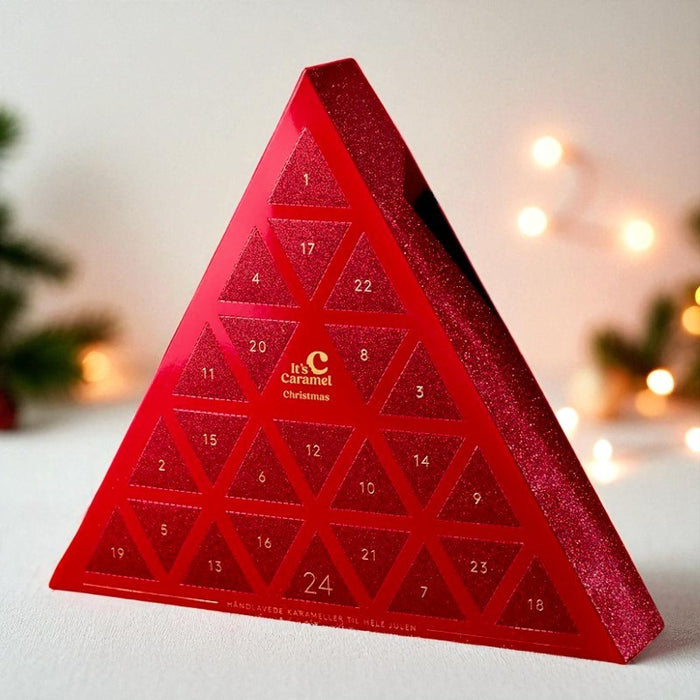 Karamelleriet julekalender i trekantet glitrende design med 24 låger fyldt med bløde fudge-karameller, chokoladeovertrukne karameller og håndlavede klippestykker.	
