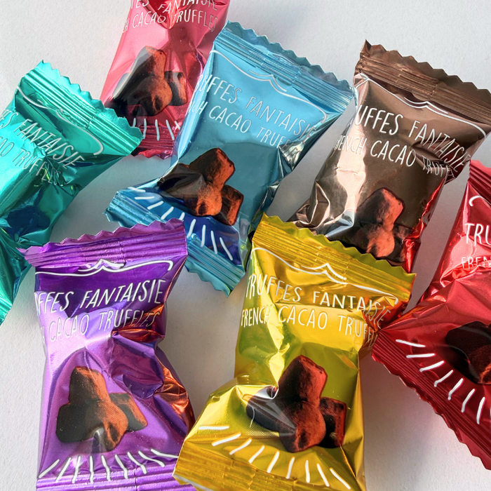 Blanding af syv Weibel chokoladetrøfler i hver sin farvede flowpack - ekstra foto