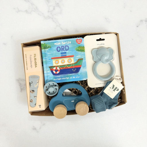 Sød og blå gaveløsning med sut, strømper og blåt legetøj til baby