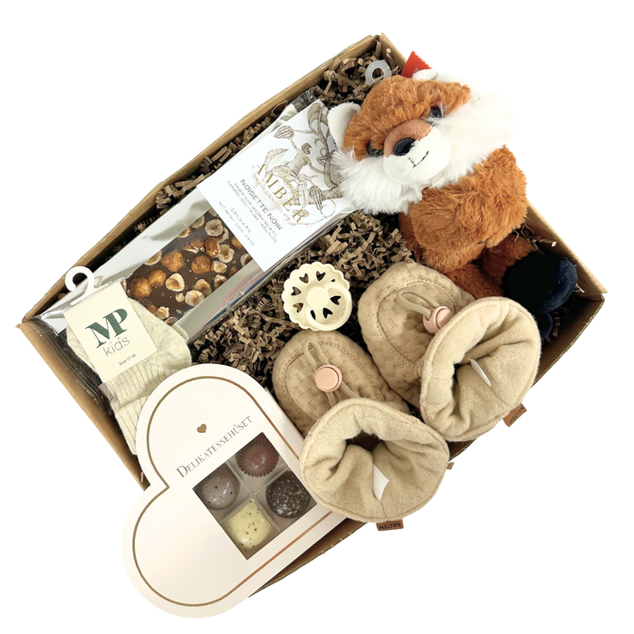 Fin gaveløsning med bamse, futter, sut, strømper og chokolade