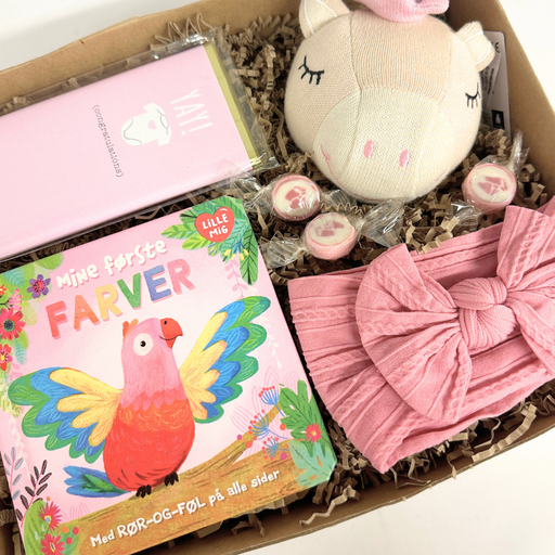 Sød lille gaveløsning med legetøj og udvikling til baby i lyserød