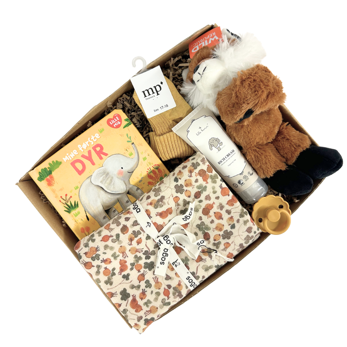 Sød gaveløsning med krammebamse, bog og andre sager til baby