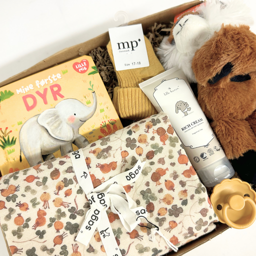 Sød gaveløsning med krammebamse, bog og andre sager til baby