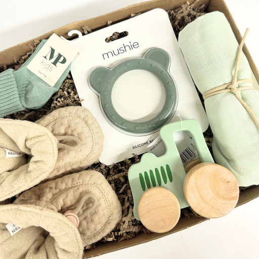 Grøn gaveløsning med traktor i træ, futter og andet til baby